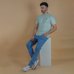 men wearing pure cotton half sleeve round neck t shirt pistachio light yellow green color breathable everyday wear premium comfort paired with premium cotton stretch light blue color EPG jeans