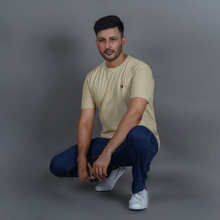 men wearing 100% gold finish beige color round neck t shirt everyday comfort in a sitting pose
