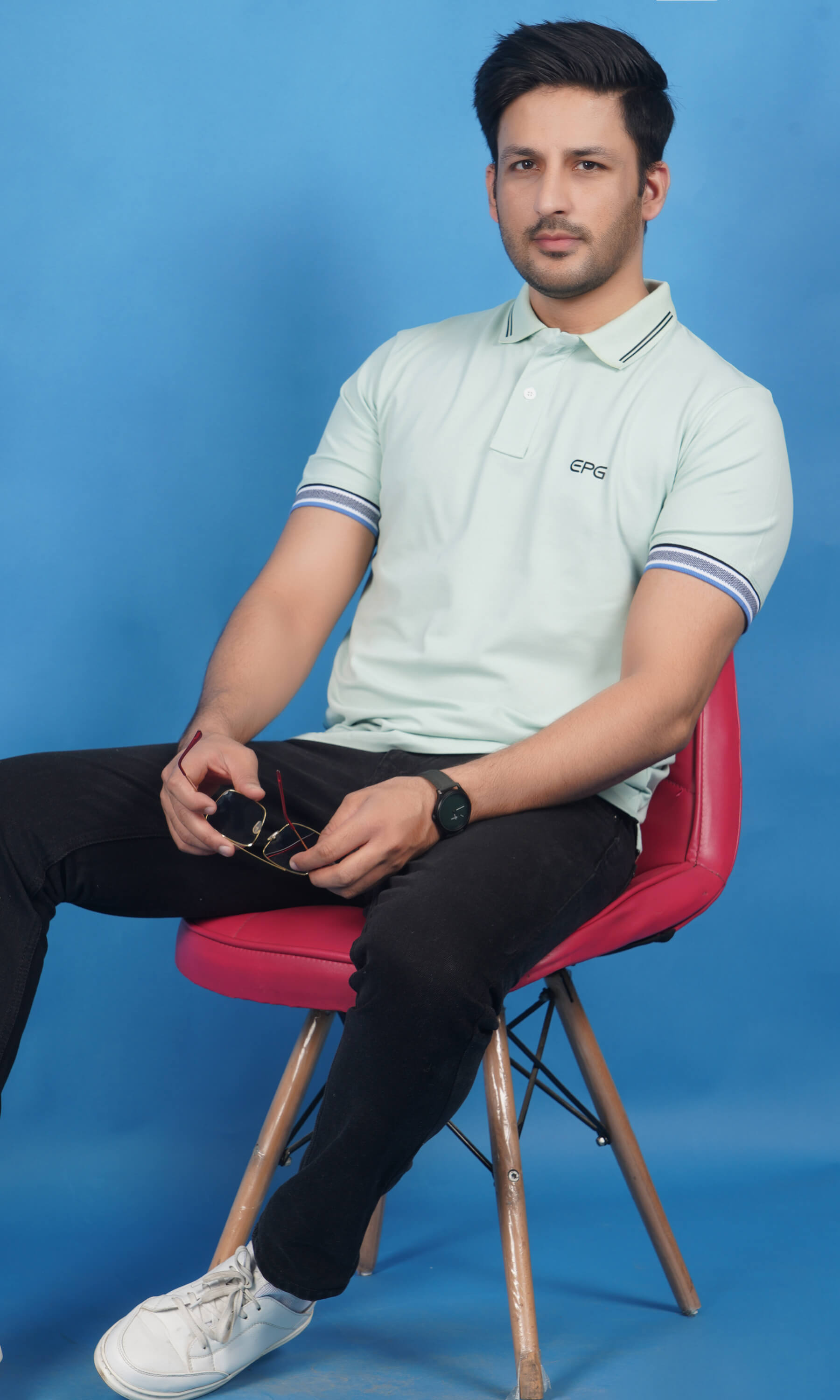 men wearing cotton lycra half sleeve polo t shirt pistachio soft green color sitting on chair breathable everyday wear premium comfort