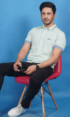 men wearing cotton lycra half sleeve polo t shirt pistachio soft green color sitting on chair breathable everyday wear premium comfort